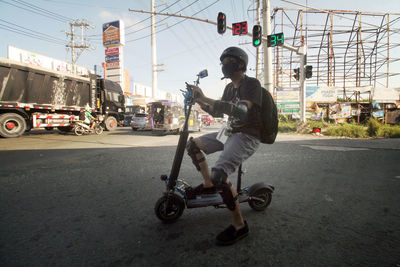 Side view of man riding motorcycle on road