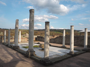 Wooden posts in row against sky