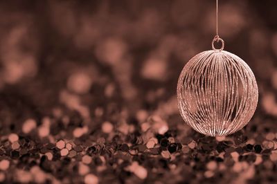 Close-up of christmas ornament hanging over sequins