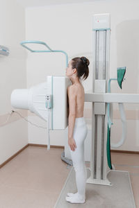 Side view of woman scanning chest in clinic