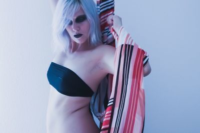 Female model wearing lingerie against white wall