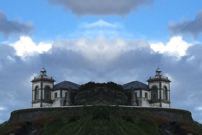 Low angle view of building against cloudy sky