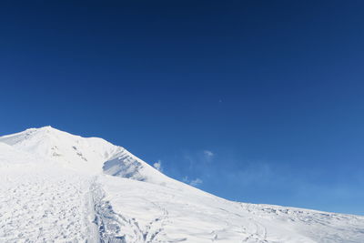 Snowcapped mountain against blue sky