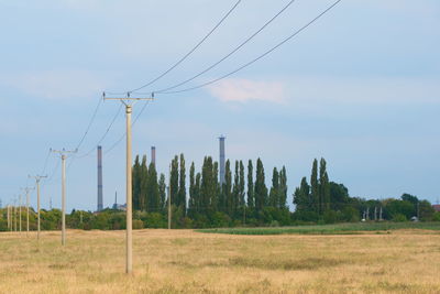 Concrete poles in line and in background multiple coal fossil fuel power plant