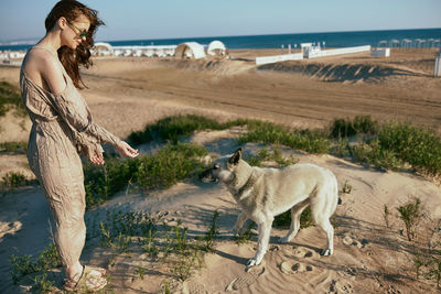 Portrait of woman standing on sand at beach