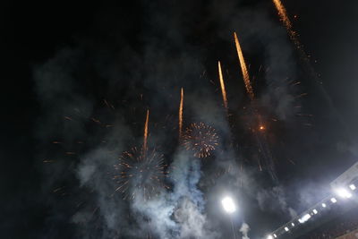 Low angle view of fireworks against sky at night