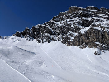 Snow covered mountain against clear blue sky