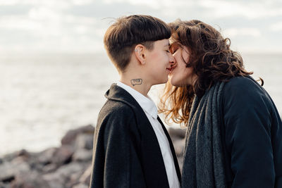 Side view of couple kissing at beach