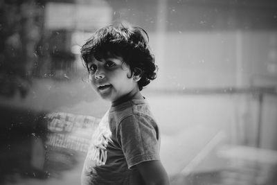 Portrait of cute boy by window at home