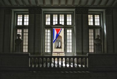 Multi colored flags on glass window of building