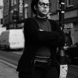 Young woman looking away while standing in city