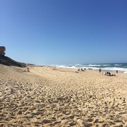 Scenic view of beach against clear blue sky