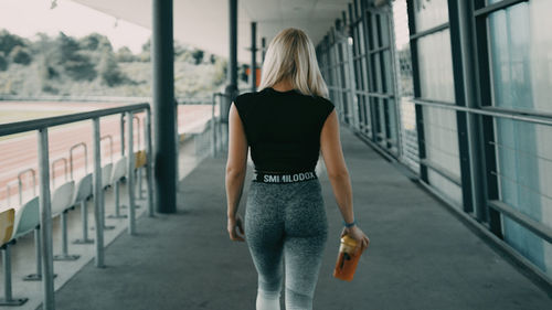 Rear view of woman standing by railing