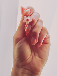 Close-up of woman holding hands over white background