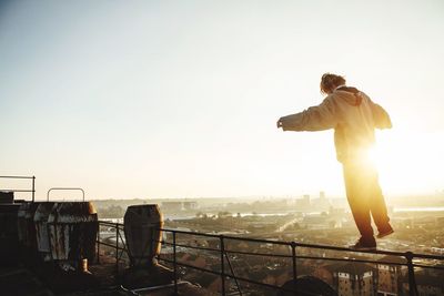 Silhouette of woman against clear sky at sunset