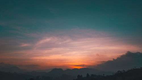 Scenic view of silhouette mountains against sky during sunset