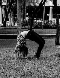 Full length of woman lying down while sitting on tree