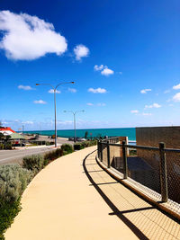 Street by sea against blue sky