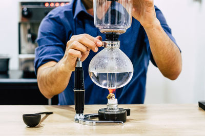 Midsection of man pouring wine in glass