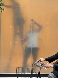 Midsection of woman using mobile phone at window