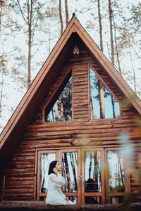 Low angle view of woman standing against building