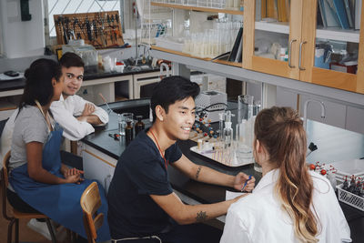 High angle view of multi-ethnic young university students sitting on chairs in chemistry laboratory