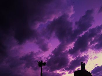 Low angle view of silhouette trees against dramatic sky