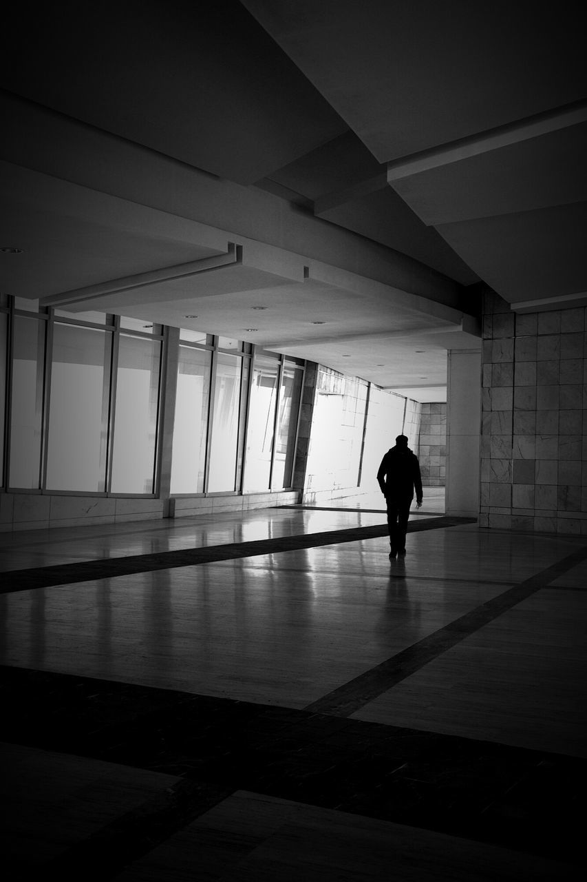 indoors, silhouette, full length, lifestyles, men, walking, rear view, built structure, ceiling, architecture, flooring, person, leisure activity, unrecognizable person, standing, sunlight, reflection, window