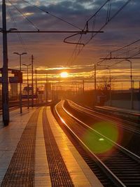 Railroad tracks against sky during sunset