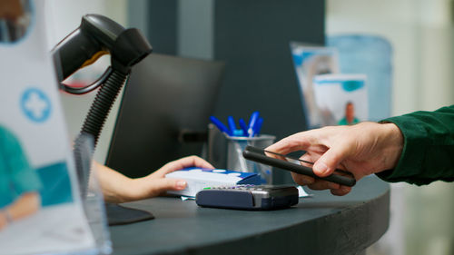 Midsection of man using mobile phone