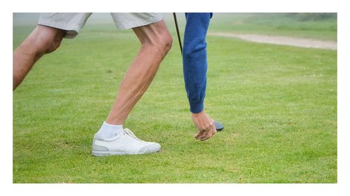 Low section of man playing golf on field