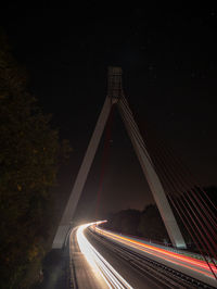 Light trails on road against sky at night