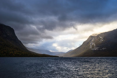 View of calm sea against mountain range