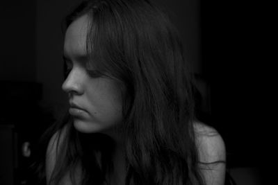 Thoughtful woman sitting in darkroom