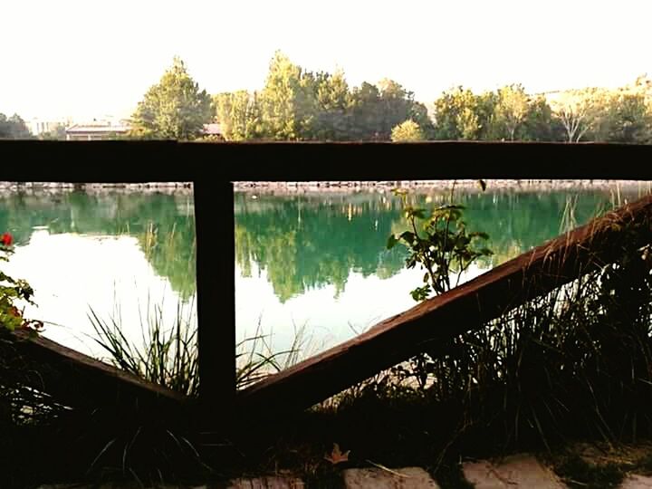 water, bridge - man made structure, connection, built structure, reflection, architecture, river, tree, bridge, sky, arch bridge, clear sky, railing, canal, transportation, lake, day, engineering, nature, footbridge