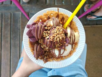 High angle view of hand holding ice cream in bowl