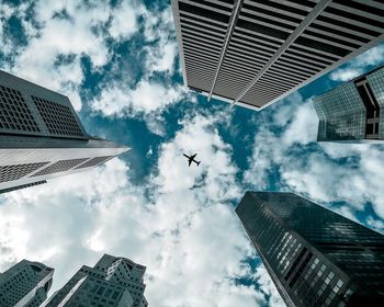 Directly below shot of airplane and buildings in city against sky