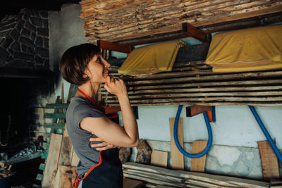 Craftswoman in a carpentry workshop looking at sawn wood