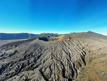 Panoramic view of arid landscape against clear blue sky