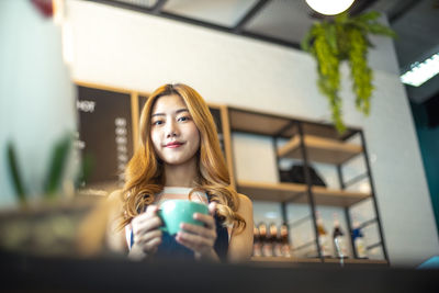 Portrait of young woman drinking coffee