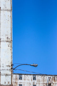 Low angle view of street light against blue sky