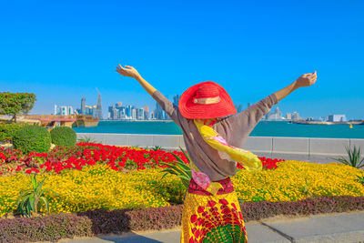 Woman with arms outstretched standing in city