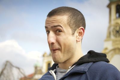 Portrait of young man making face while standing outdoors