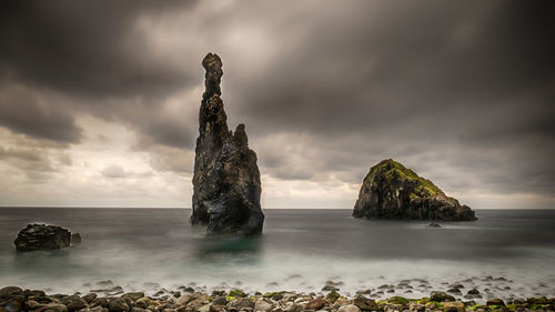 Scenic view of rocks in sea against sky