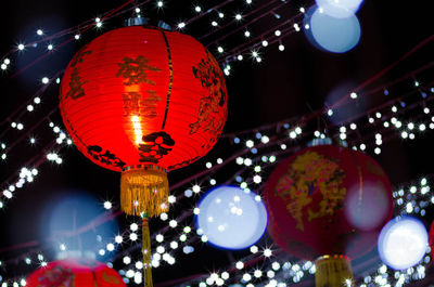 Low angle view of illuminated lanterns hanging against sky