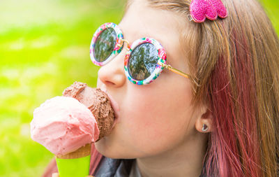 Close-up of cute girl wearing sunglasses while eating ice cream outdoors