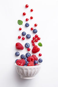 Fruits in bowl against white background