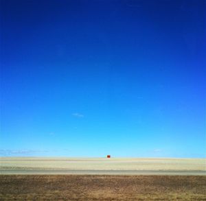 Scenic view of desert against clear blue sky