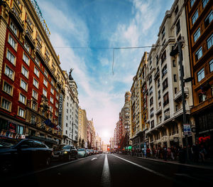 Road amidst buildings in city against sky