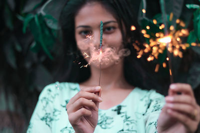 Portrait of teenage girl holding sparklers